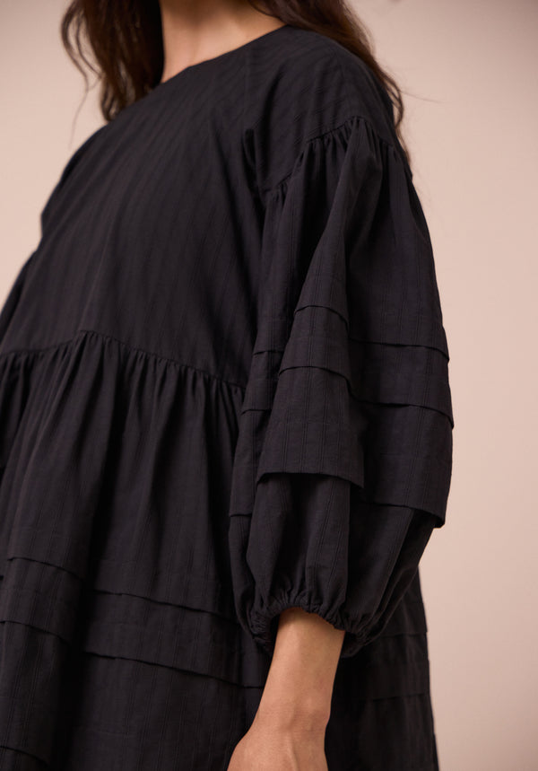 model wears nine black self stripe dress