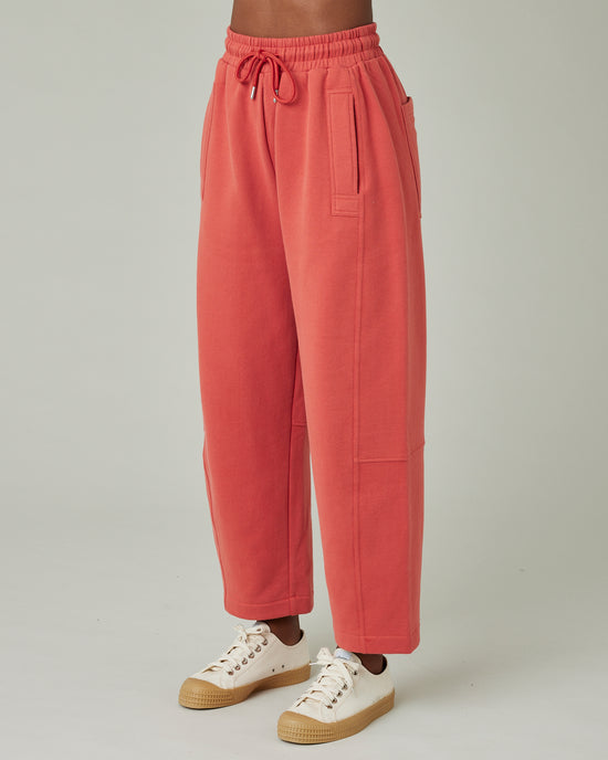 model wears terracotta jersey madi trousers left