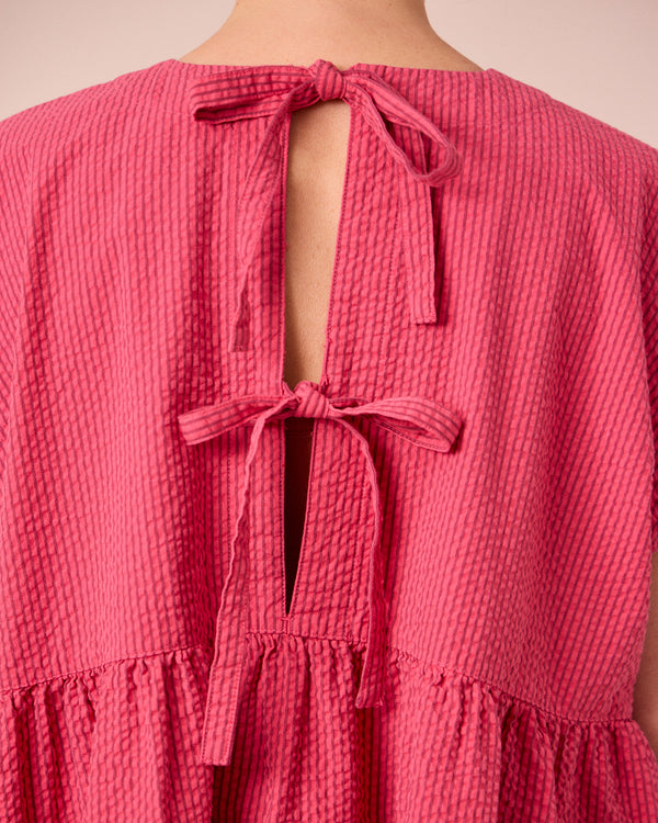 model wears nola raspberry stripe seersucker top