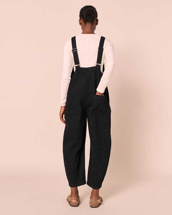 model wears ophelia black leopard denim jumpsuit