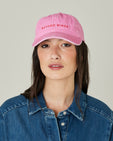 model wears pink beyond niner cap