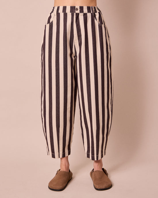 model wears remi ecru and chocolate denim jeans front