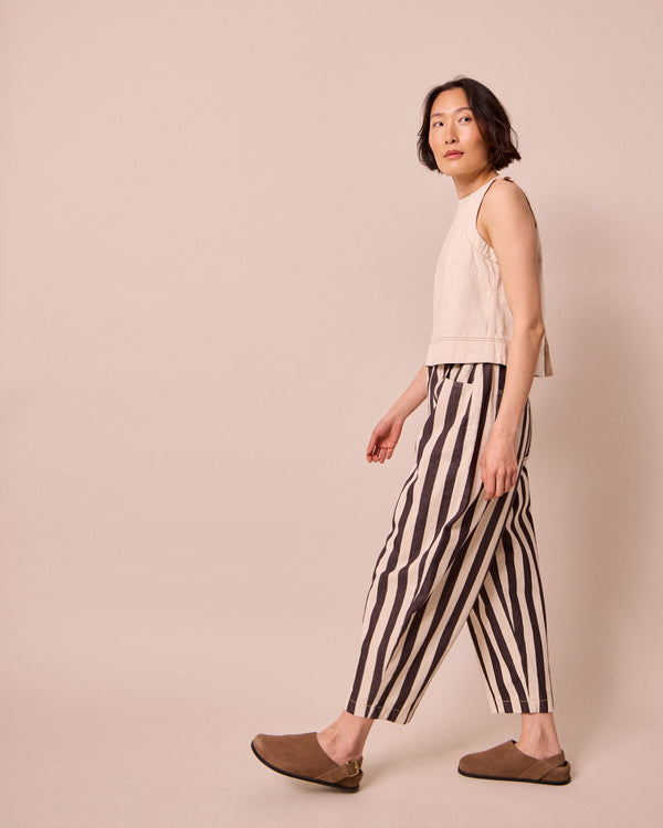 model wears remi ecru and chocolate denim jeans right