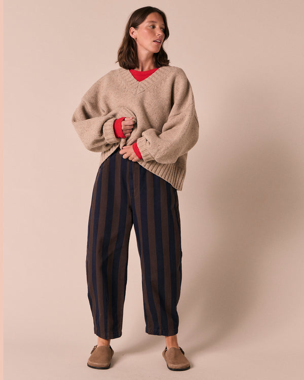 model wears remi navy and chocolate stripe denim jeans left