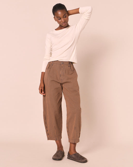model wears remi nutmeg pinstripe denim jeans left
