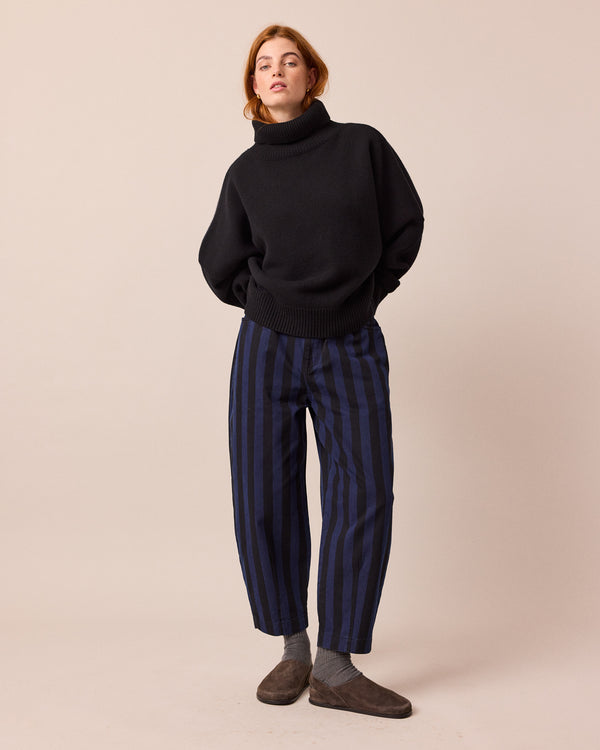 model wears remi blue and black denim jeans right