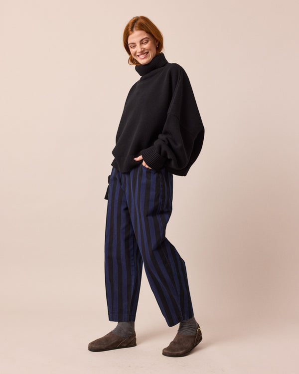 model wears remi blue and black denim jeans left