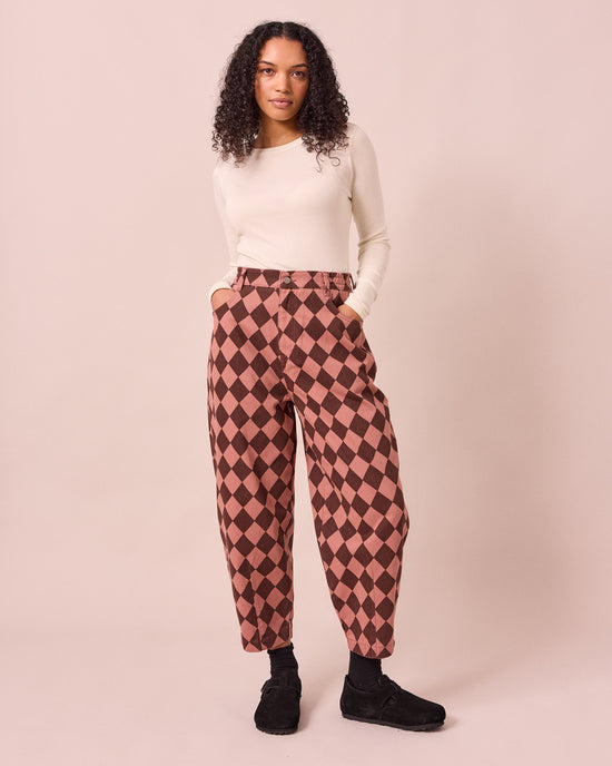 model wears remi clay pink and chocolate harlequin denim jeans left