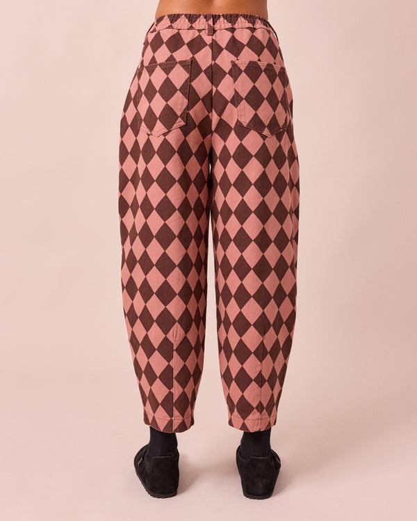 model wears remi clay pink and chocolate harlequin denim jeans back