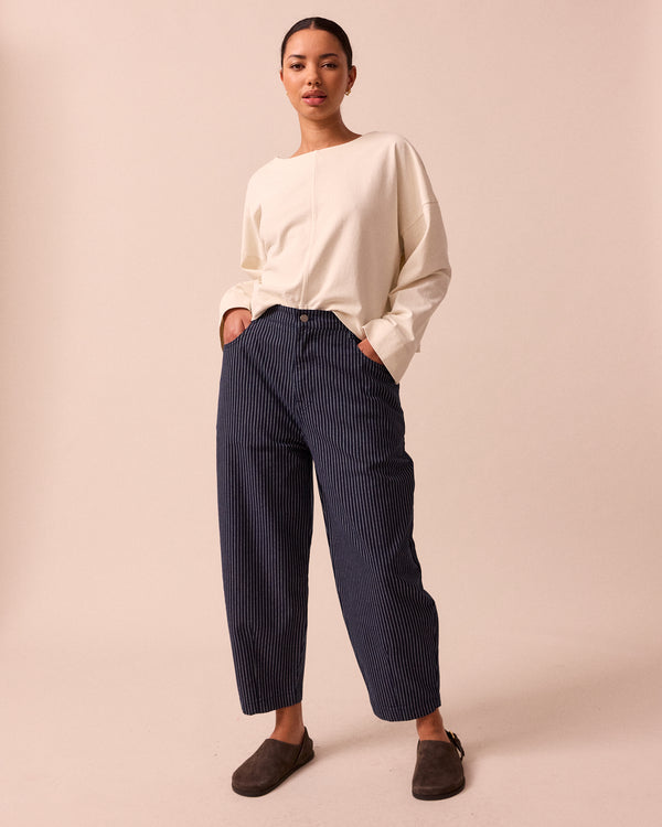 model wears remi navy pinstripe denim trousers back