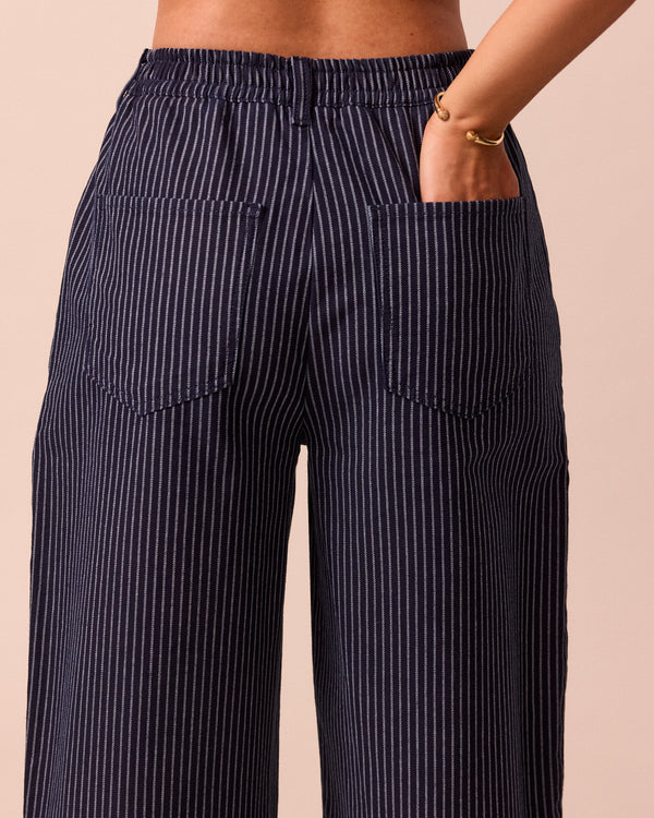model wears remi navy pinstripe denim trousers right
