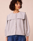 model wears rowen blue and ecru stripe seersucker top