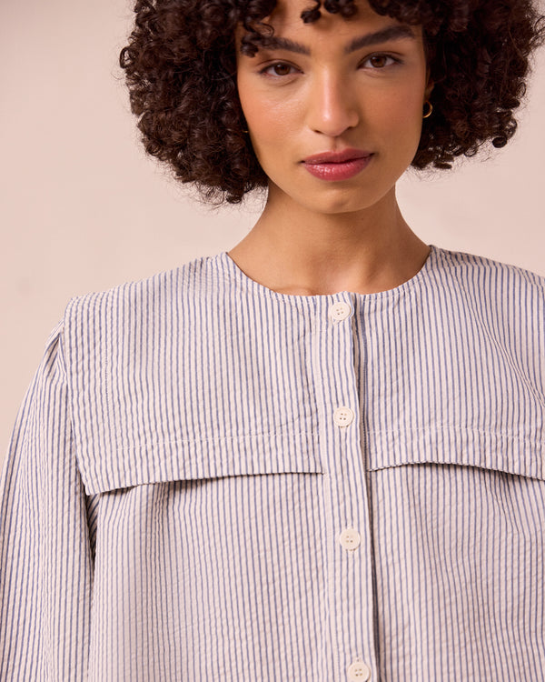 model wears rowen blue and ecru stripe seersucker top