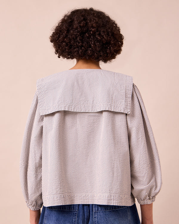 model wears rowen blue and ecru stripe seersucker top