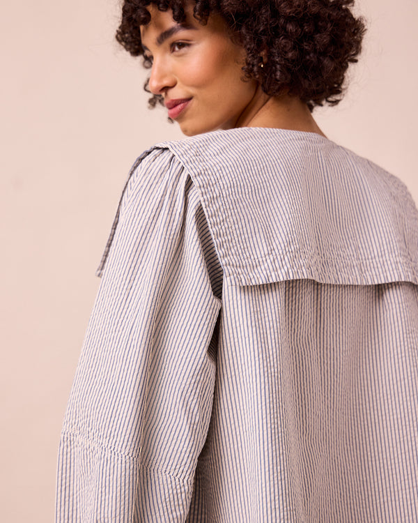 model wears rowen blue and ecru stripe seersucker top