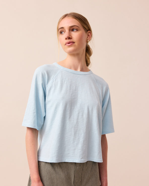 model wears sky blue raglan tee
