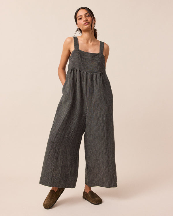 model wears black and ecru pencil stripe cari linen jumpsuit