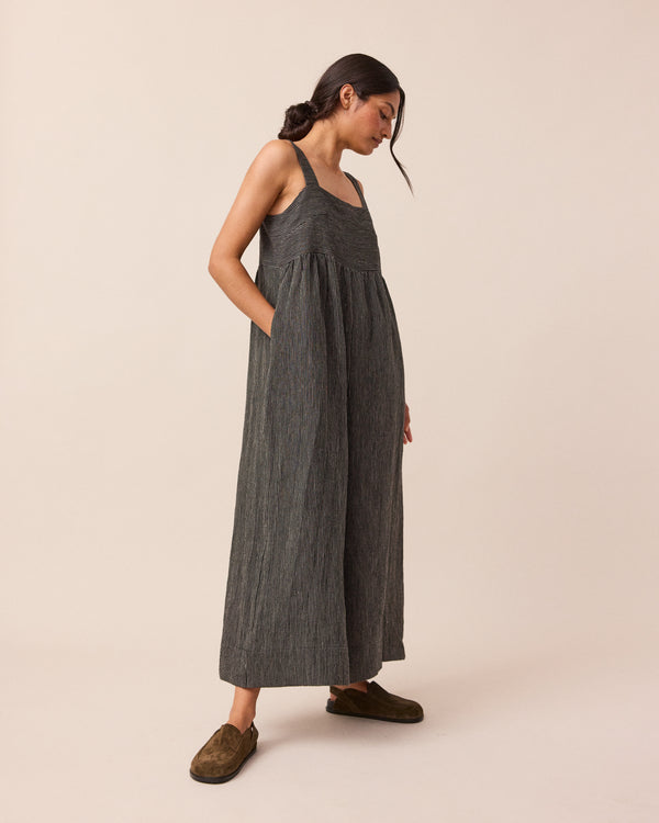 model wears black and ecru pencil stripe cari linen jumpsuit