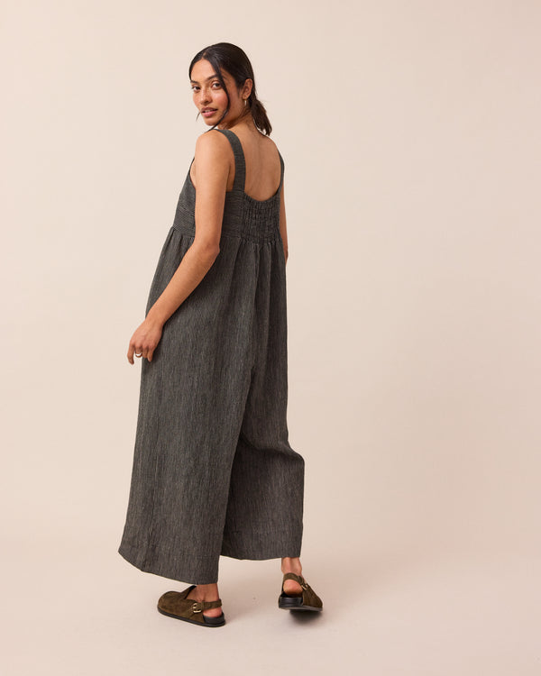 model wears black and ecru pencil stripe cari linen jumpsuit