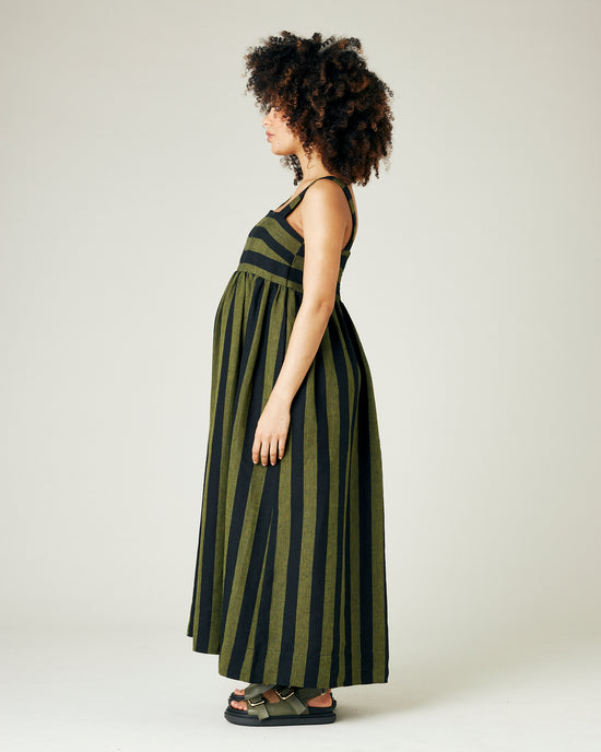 pregnant model wears olive and black stripe linen suki dress