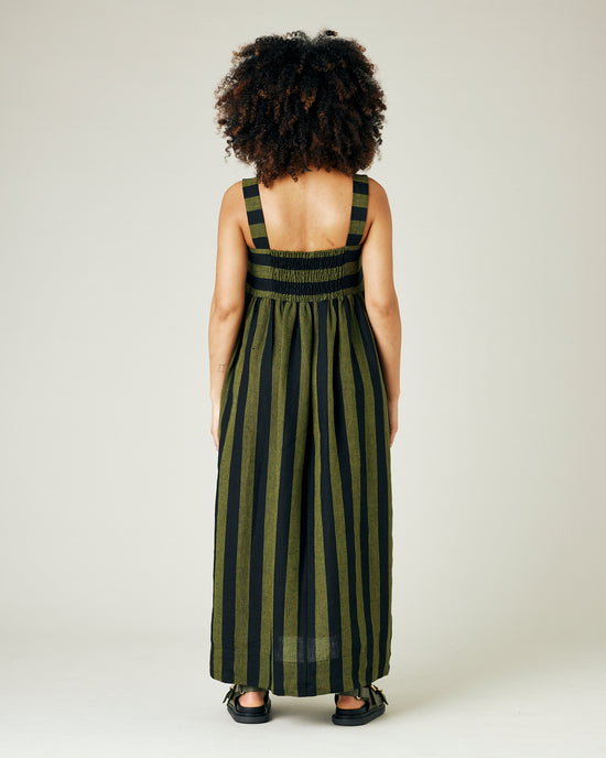 pregnant model wears olive and black stripe linen suki dress