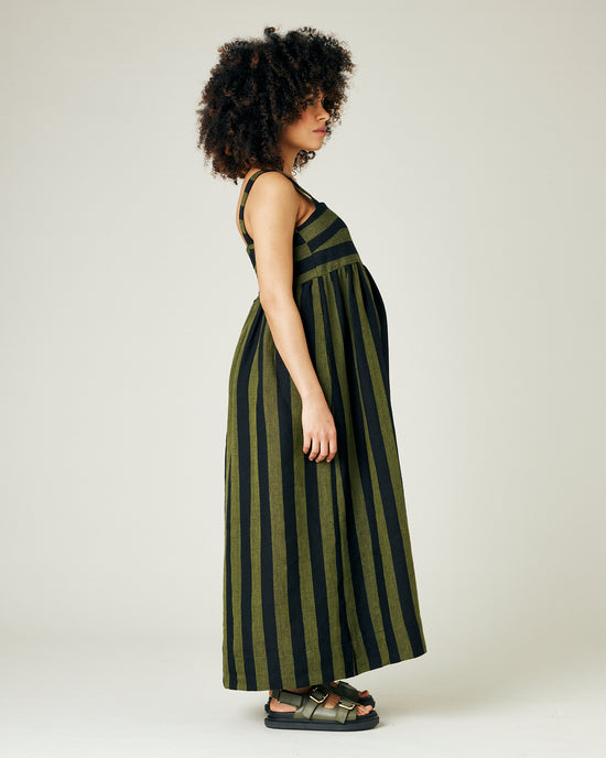 pregnant model wears olive and black stripe linen suki dress