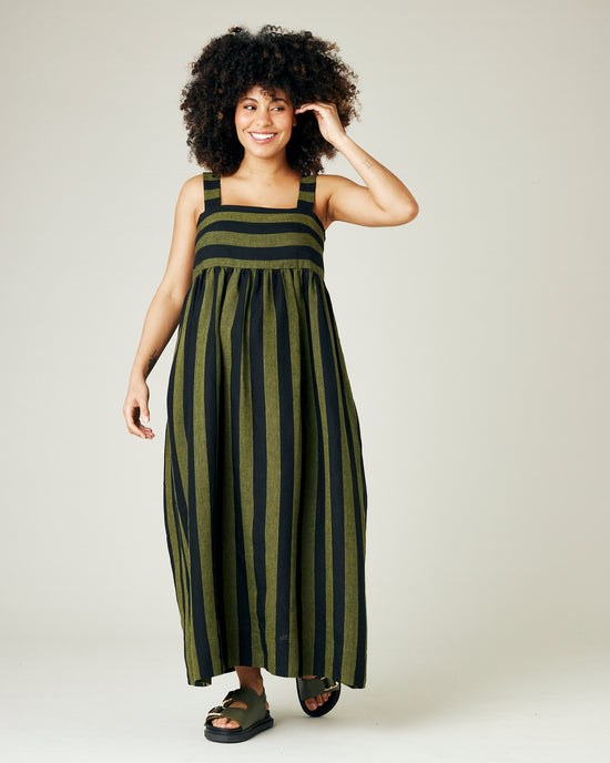 pregnant model wears olive and black stripe linen suki dress