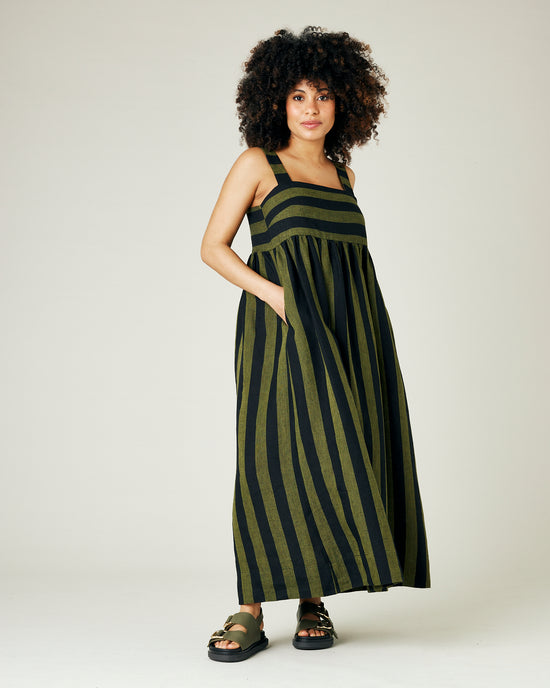 pregnant model wears olive and black stripe linen suki dress