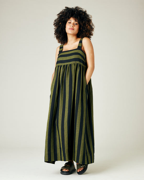 pregnant model wears olive and black stripe linen suki dress