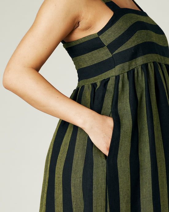 pregnant model wears olive and black stripe linen suki dress