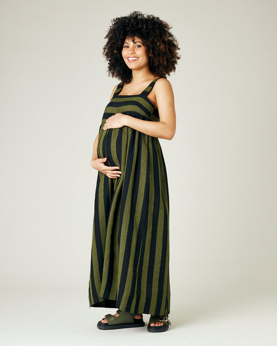 pregnant model wears olive and black stripe linen suki dress