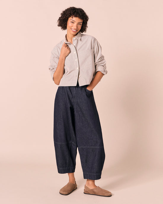 model wears sura indigo rinse wash denim jeans left