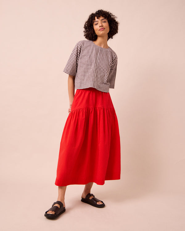 model wears talia chilli red cotton poplin skirt