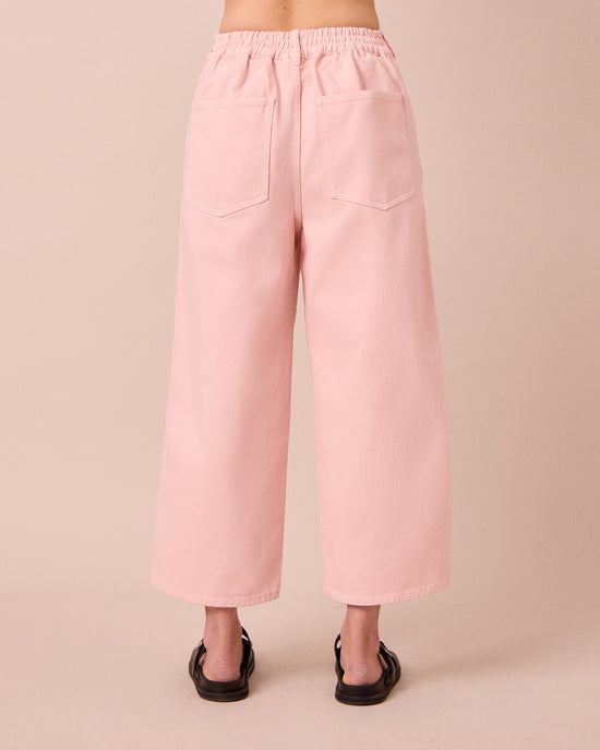 model wears tavi petal pink denim jeans back