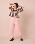 model wears tavi petal pink denim jeans left