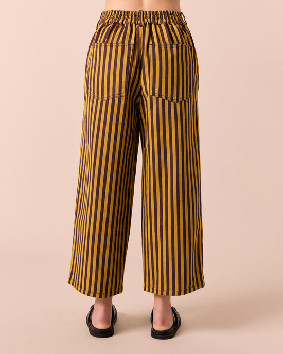 model wear tavi saffron and chocolate stripe jeans