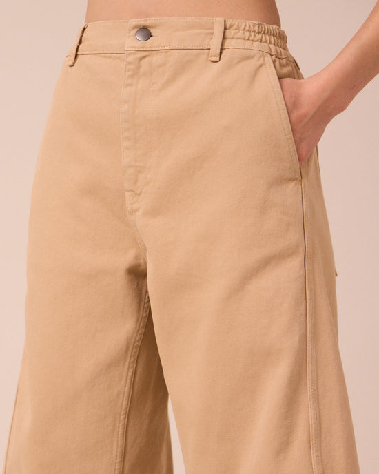 model wears tori sandstone denim jeans