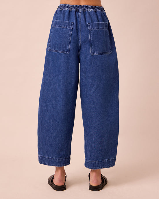 model wears vedamid blue denim jeans back