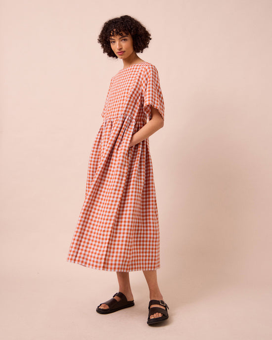 model wears verona burnt orange gingham linen dress