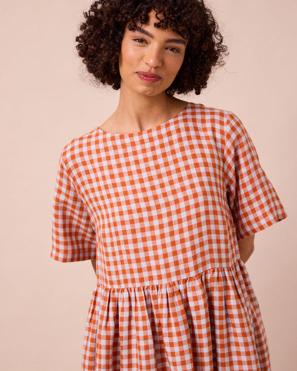 model wears verona burnt orange gingham linen dress