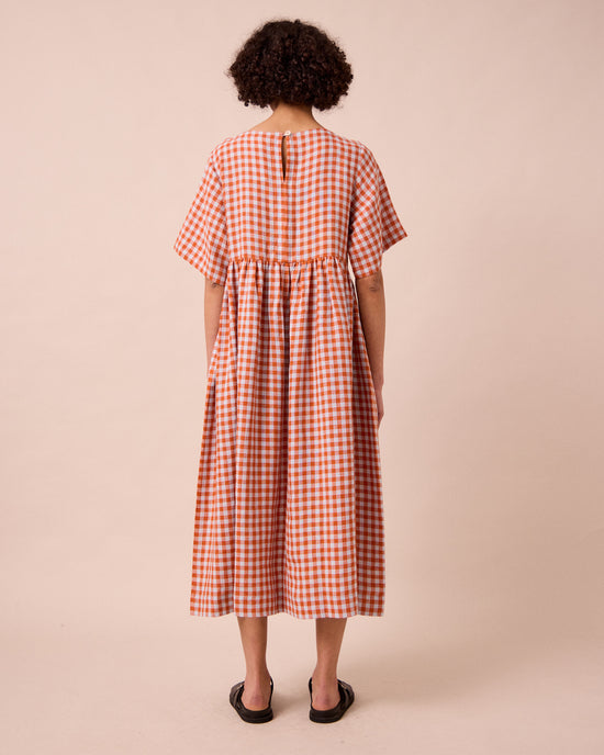 model wears verona burnt orange gingham linen dress