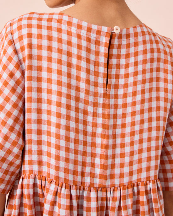 model wears verona burnt orange gingham linen dress