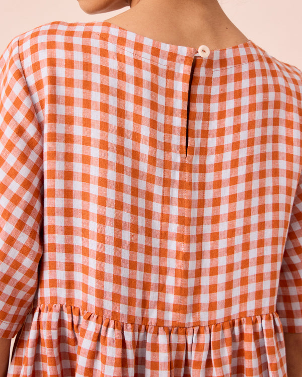 model wears verona burnt orange gingham linen dress