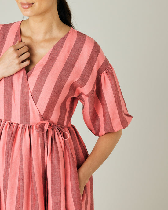 pregnant model wears blush stripe linen winnie dress