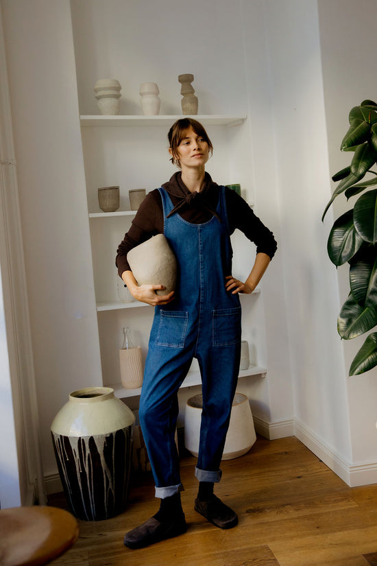 model wears lola mid blue denim jumpsuit