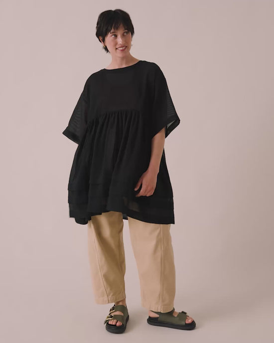 model wears neve black sheer stripe dress
