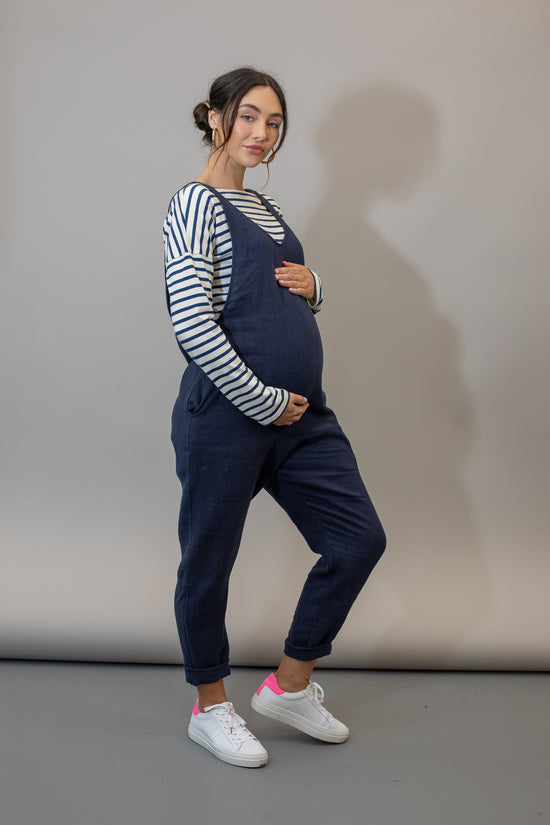 pregnant model wears navy linen laura jumpsuit