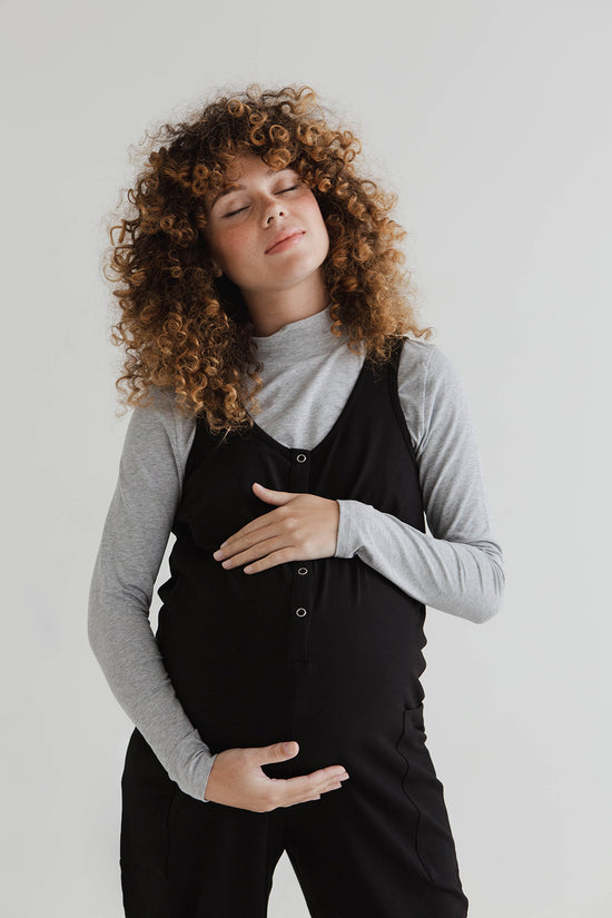 pregnant model wears black jersey poppy jumpsuit