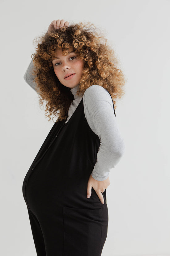 pregnant model wears black jersey poppy jumpsuit