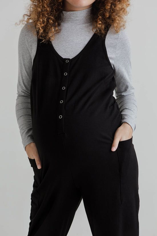 pregnant model wears black jersey poppy jumpsuit